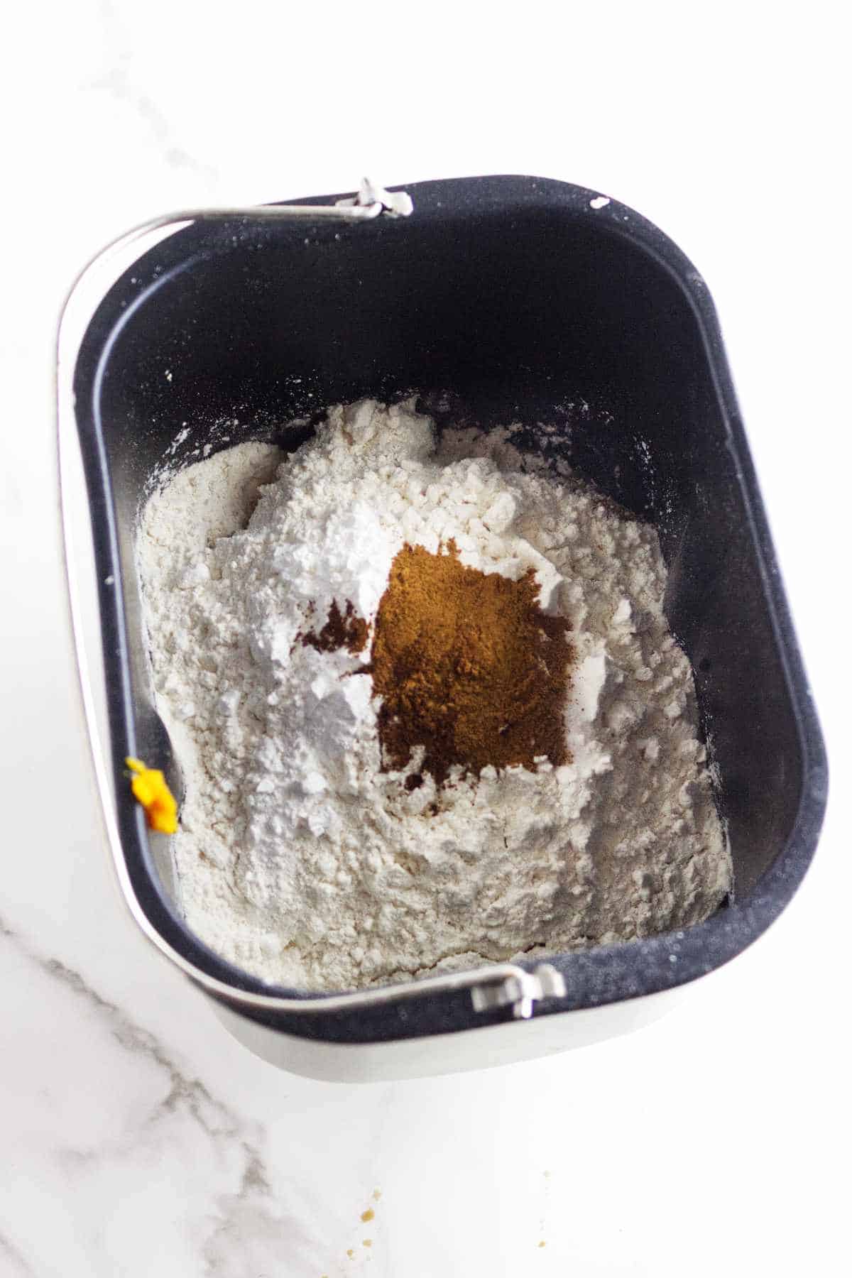 dry ingredients and pumpkin pie spice in a bread machine pan.