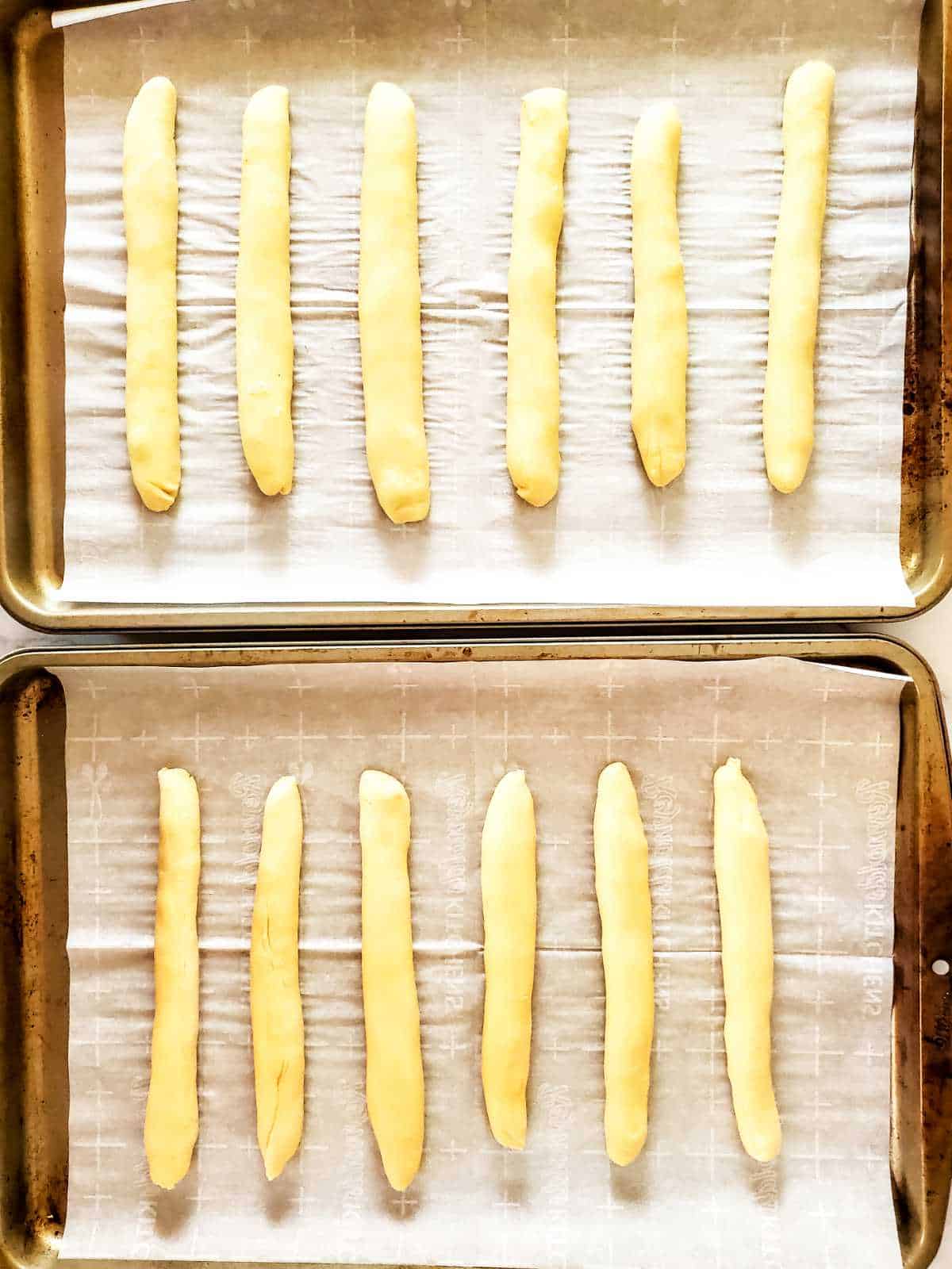 dough shaped into breadsticks, proofing.