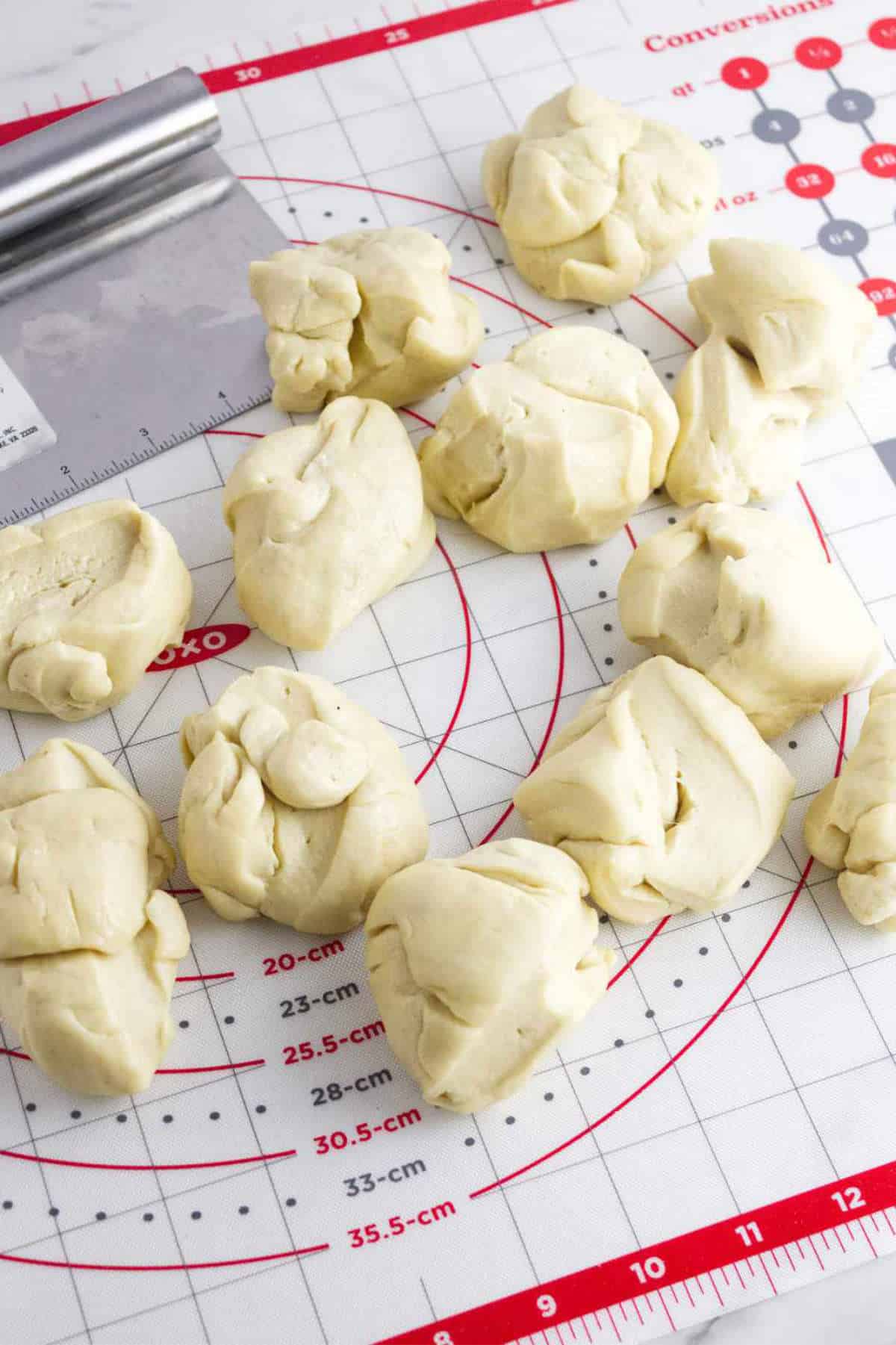 cutting dough into smaller pieces for Challah rolls.