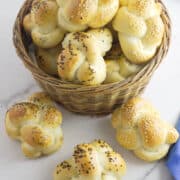basket of golden brown, seeded challah rolls.