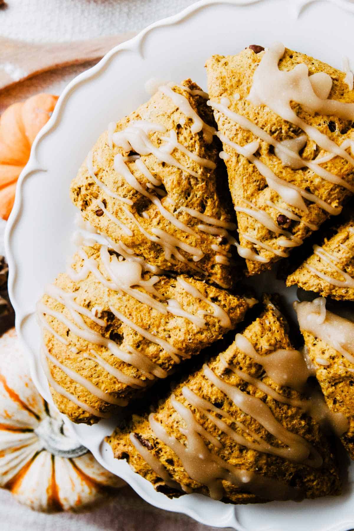 Pumpkin scones with maple icing on a platter.