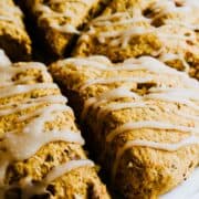 Pumpkin scones with maple icing on a platter.