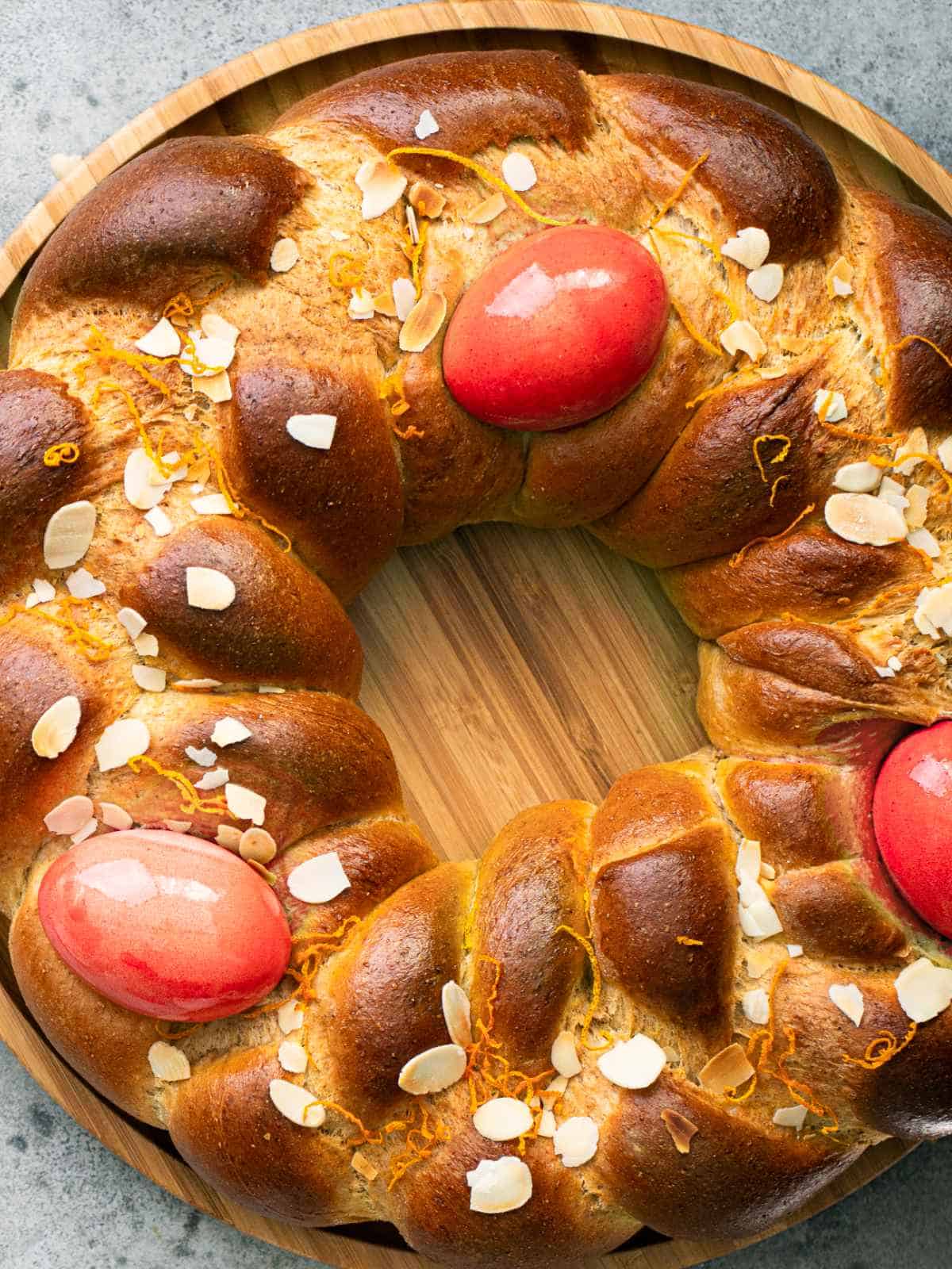 Greek Easter Tsoureki bread wreath with red eggs tucked into it.