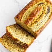 sliced cooled banana bread on a marble countertop.