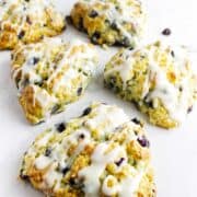 blueberry lemon scones with a lemon glaze drizzled on them.