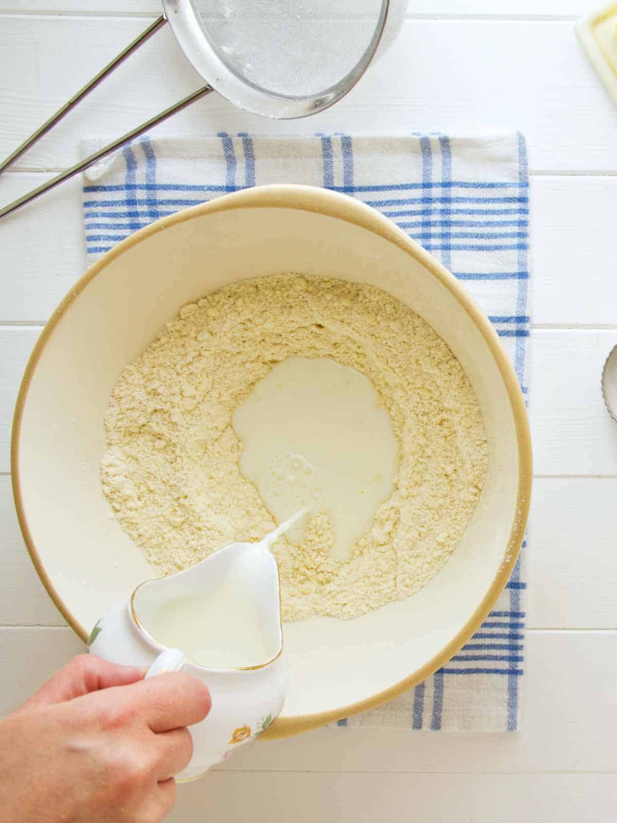 Adding milk to flour mixture.