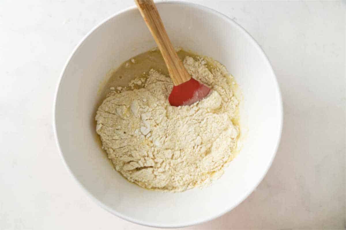 combining dry cornbread ingredients into a bowl of wet ingredients.