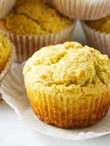 cornbread muffins with wrappers stacked up.