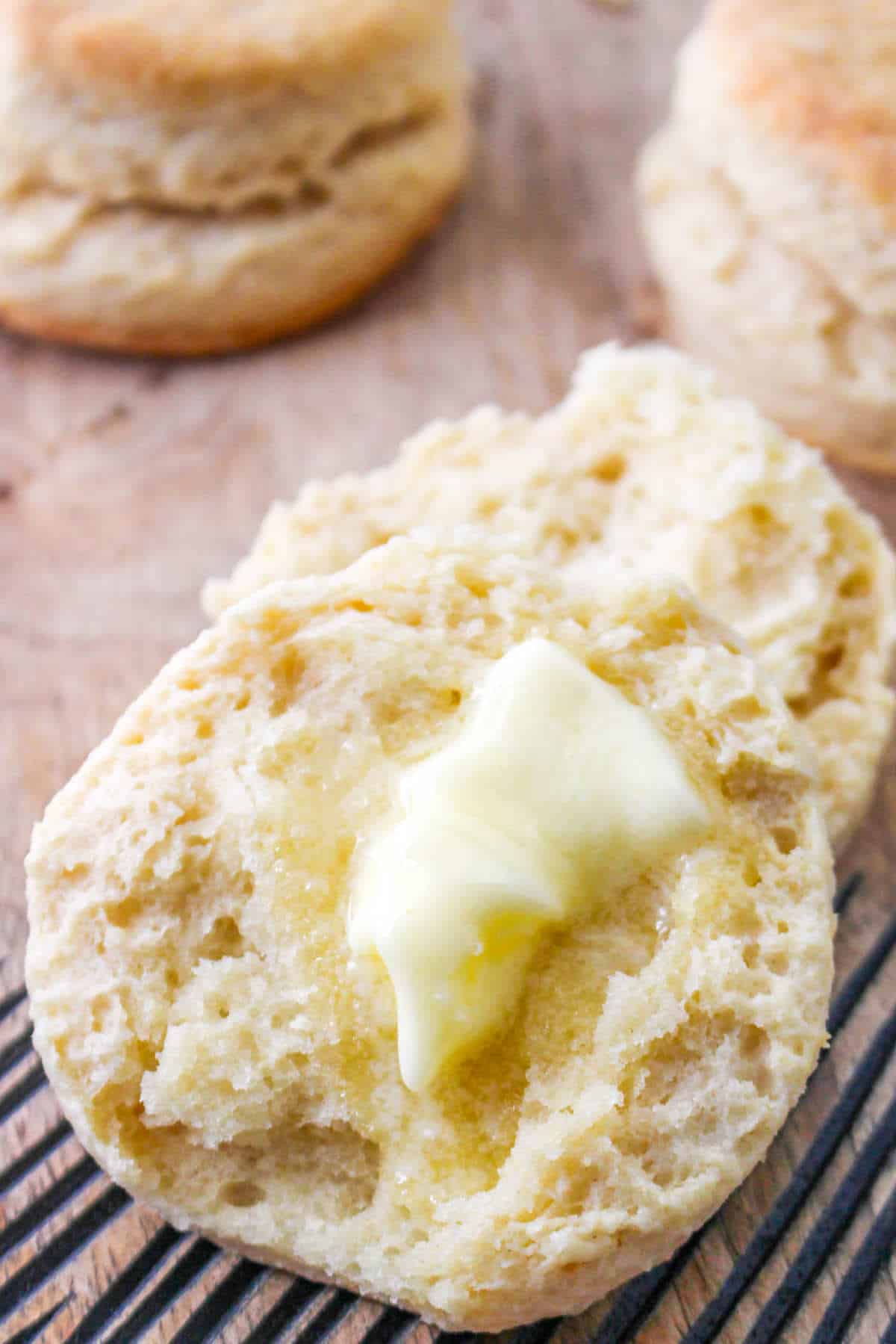 fresh baked Old-Fashioned Buttermilk Biscuits with hot butter melting on it.