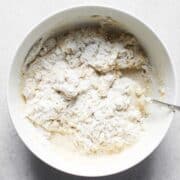 shaggy mixture of flour, yeast, and water for a pate fermentee in a small bowl.