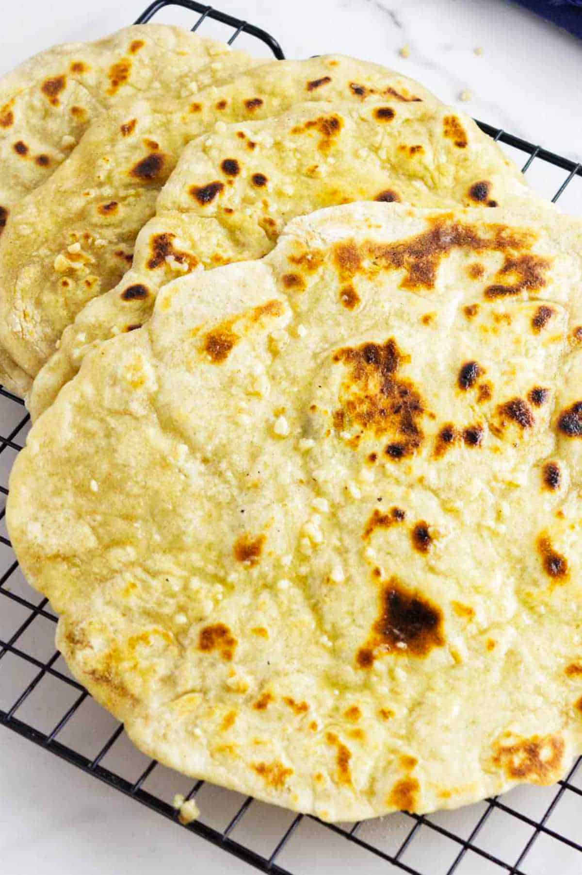 sourdough discard naan flatbreads on a cooling rack.