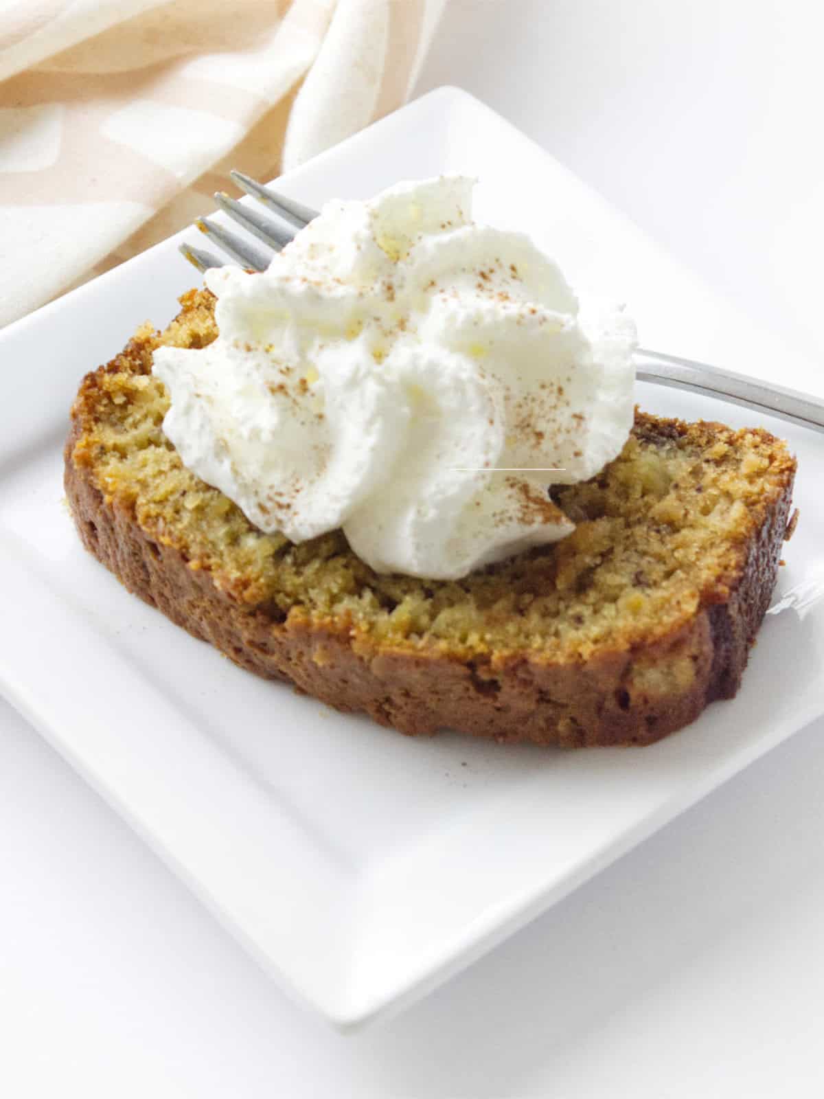 sliced banana pineapple bread with cinnamon topped whip cream.