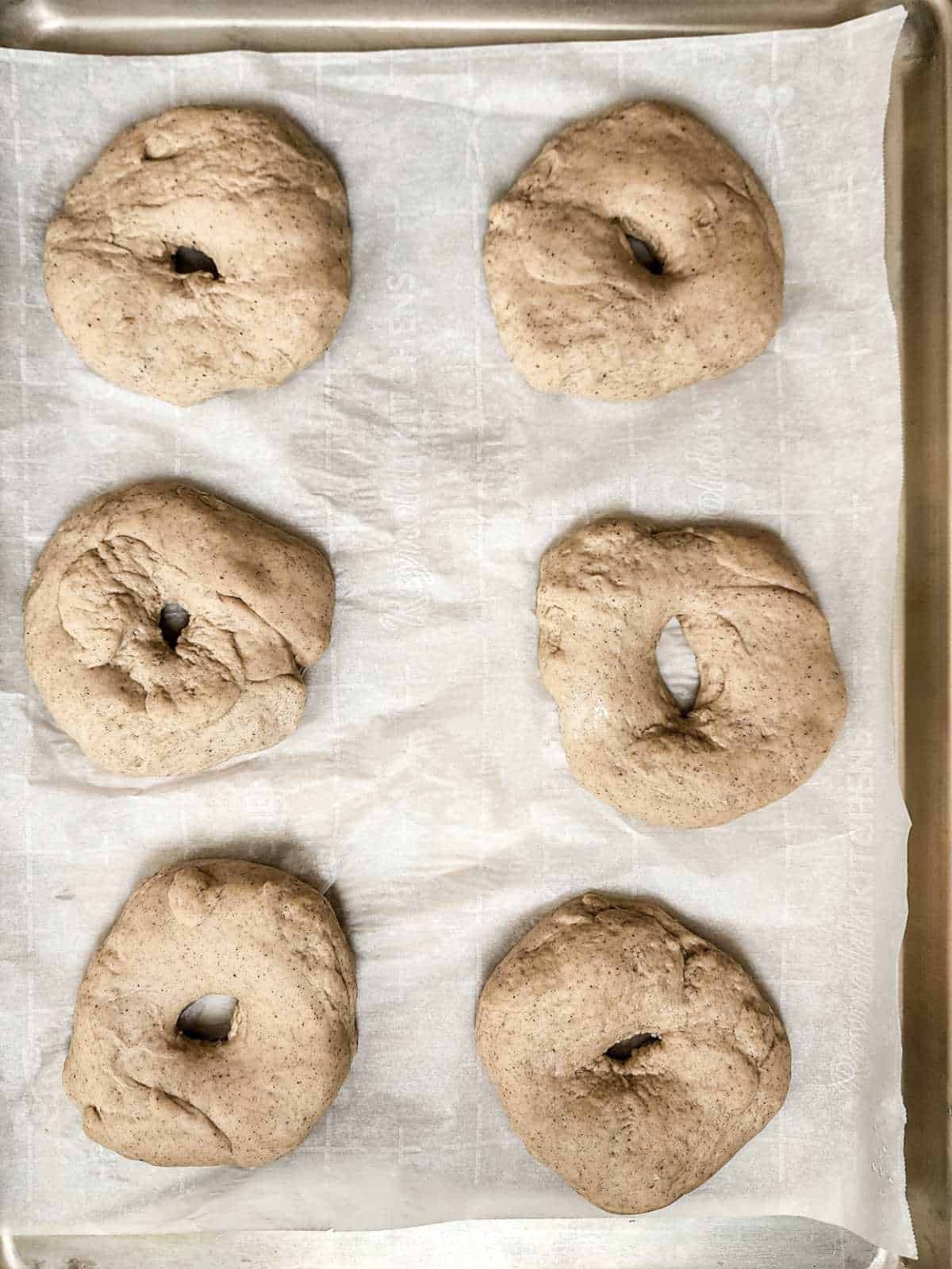 shaped bagels on a baking sheet.