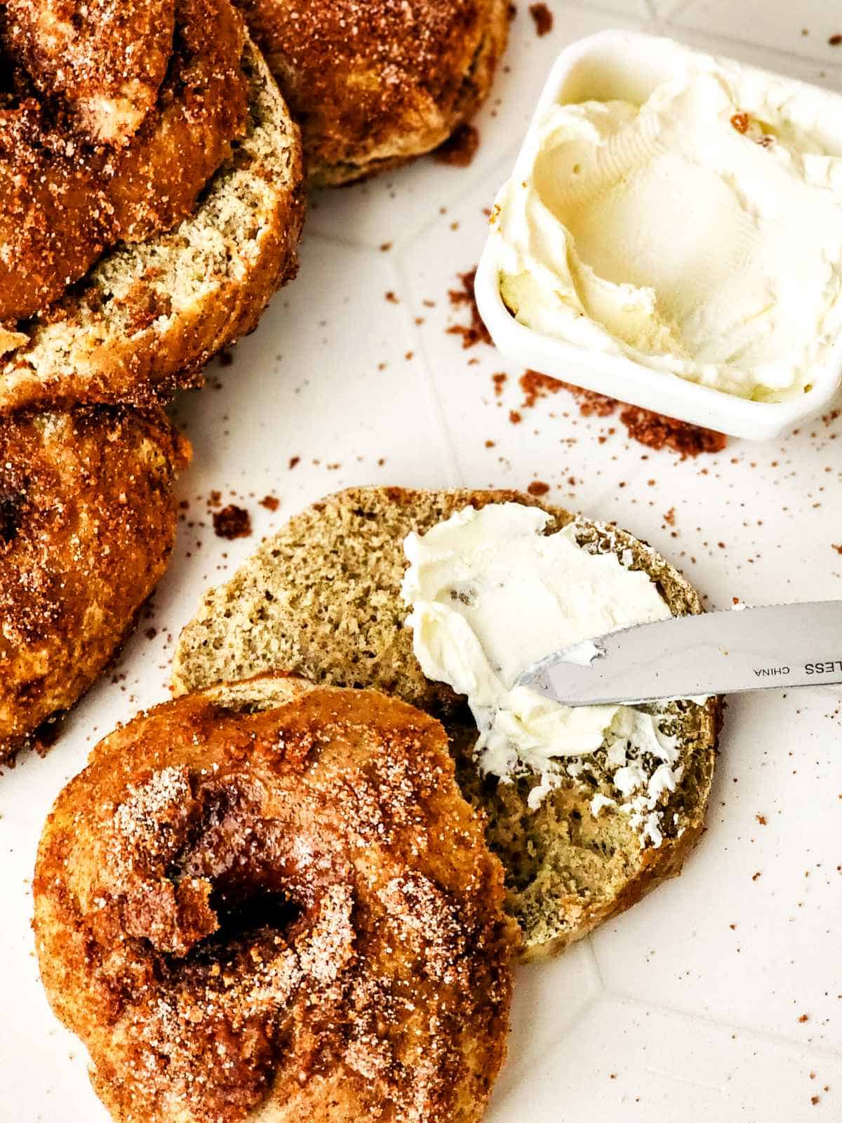 cinnamon bagels split with cream cheese spread.