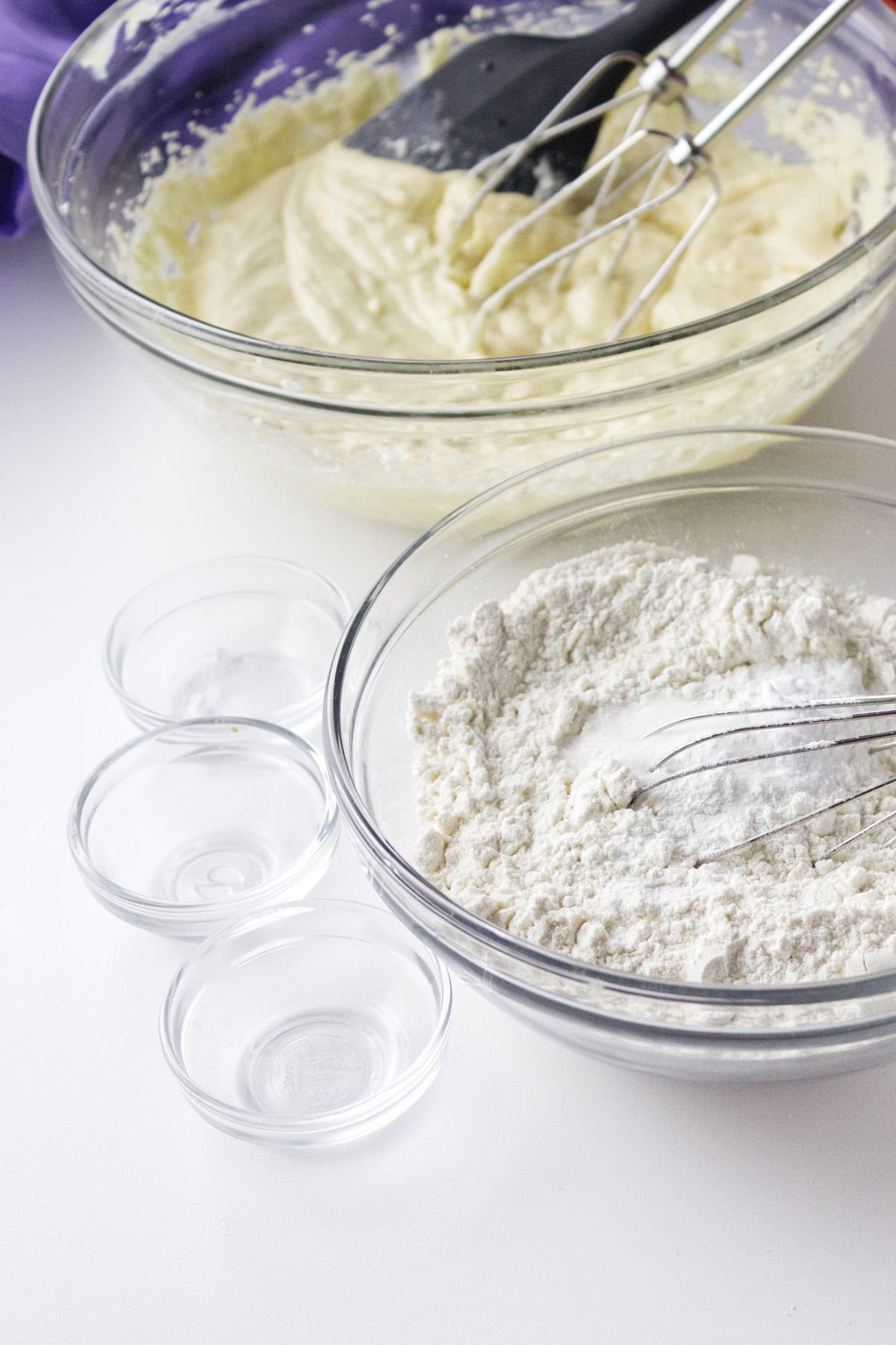 mixed butter and sugar in a bowl with a second bowl of flour and baking powder.