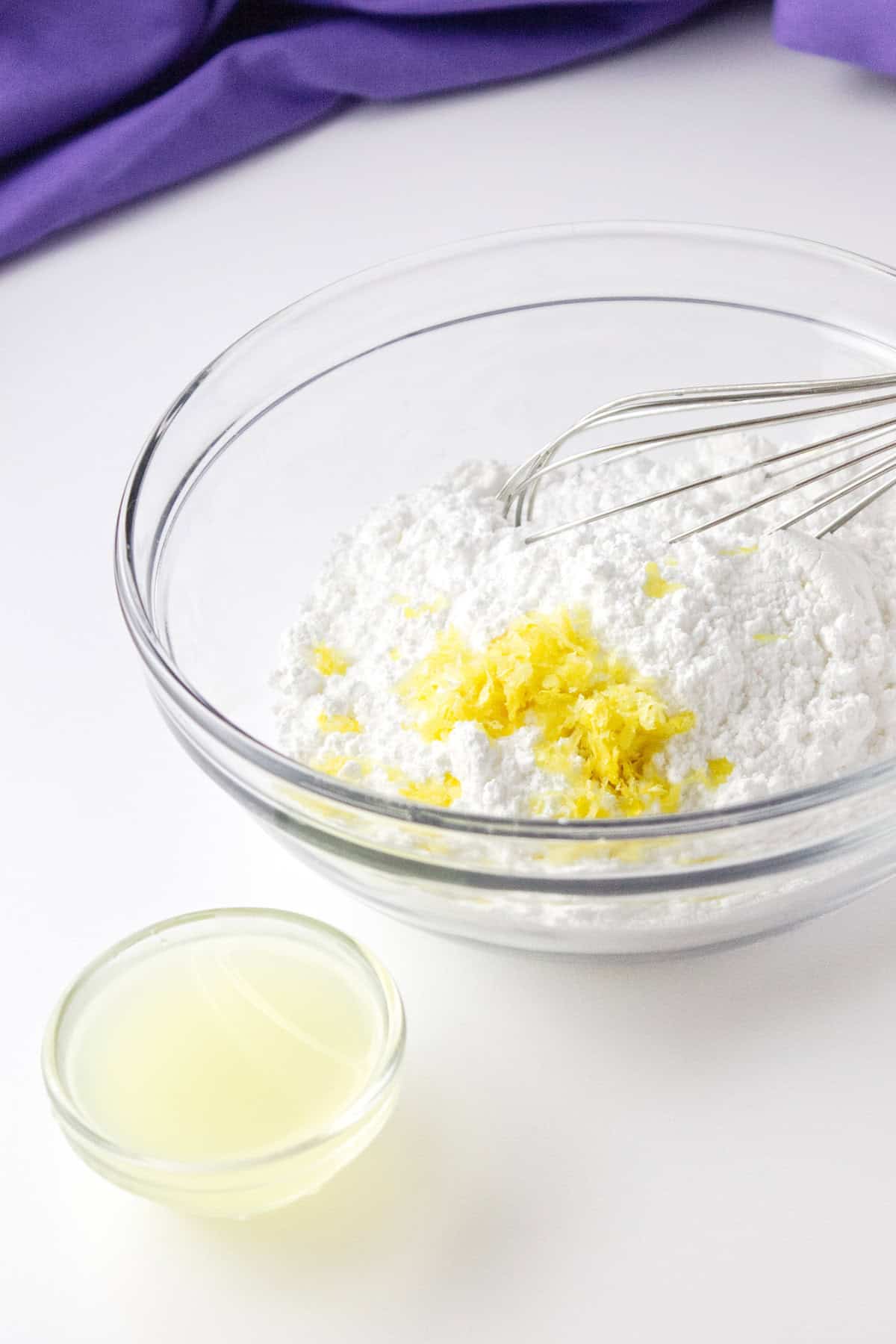 mixing lemon zest and lemon juice into powdered sugar for a glaze.