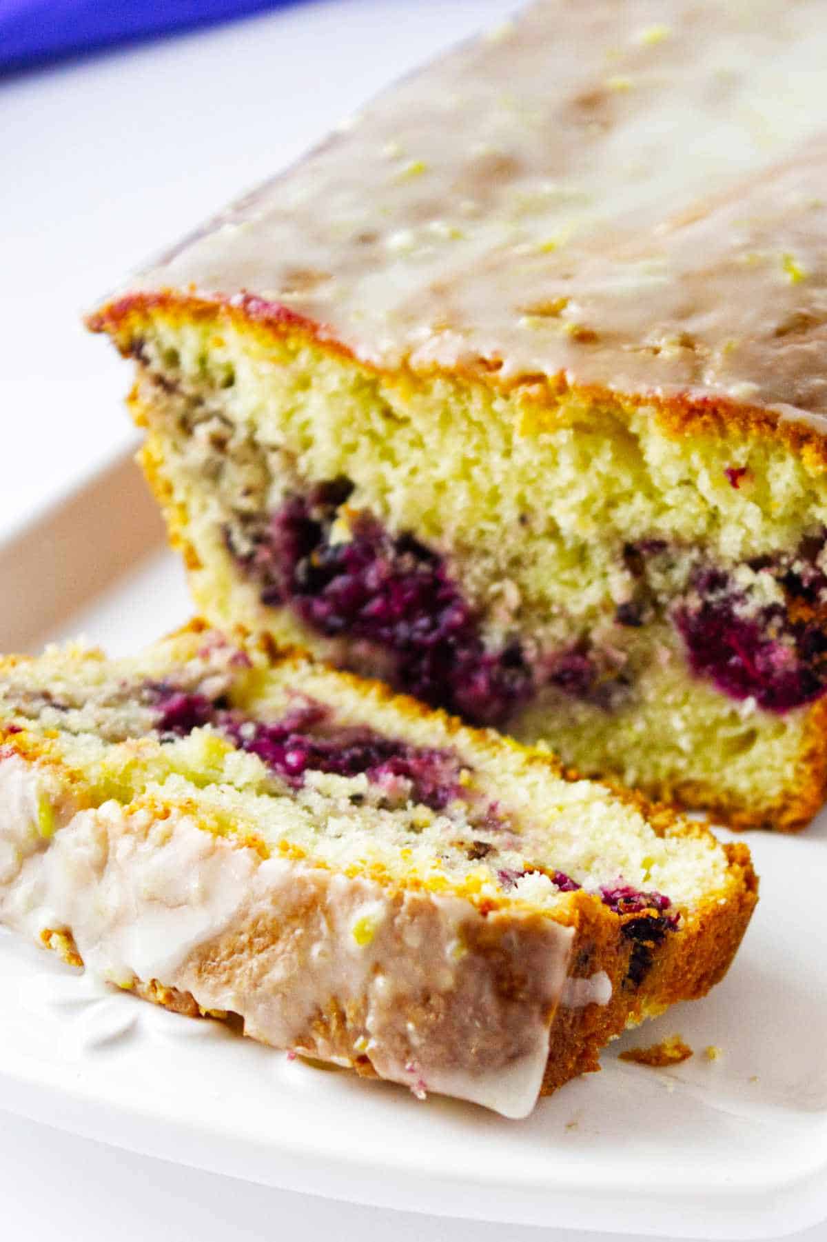 Lemon blackberry bread on a platter with glaze.