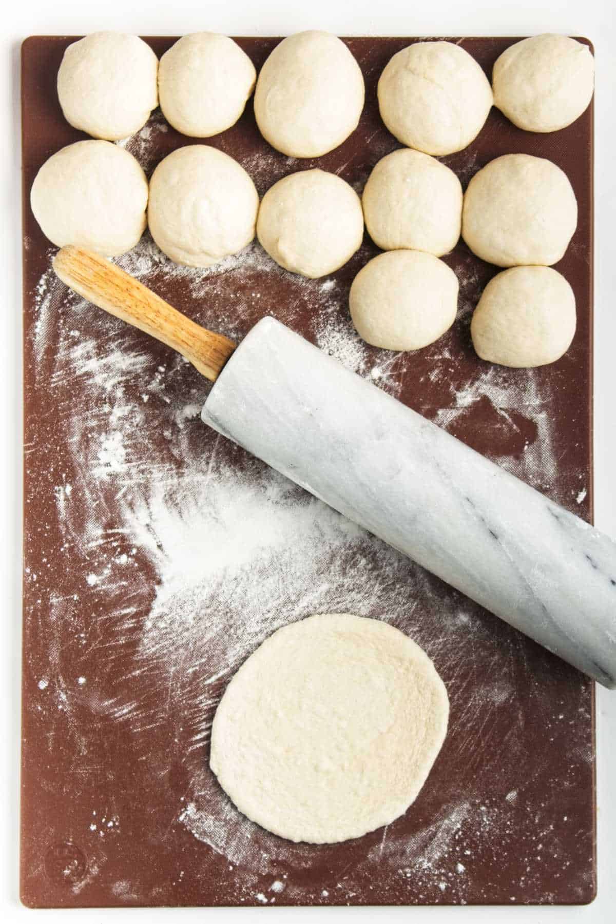 rolling small balls out into mini pita breads.