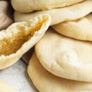 mini pita bread cooling on a wood cutting board.