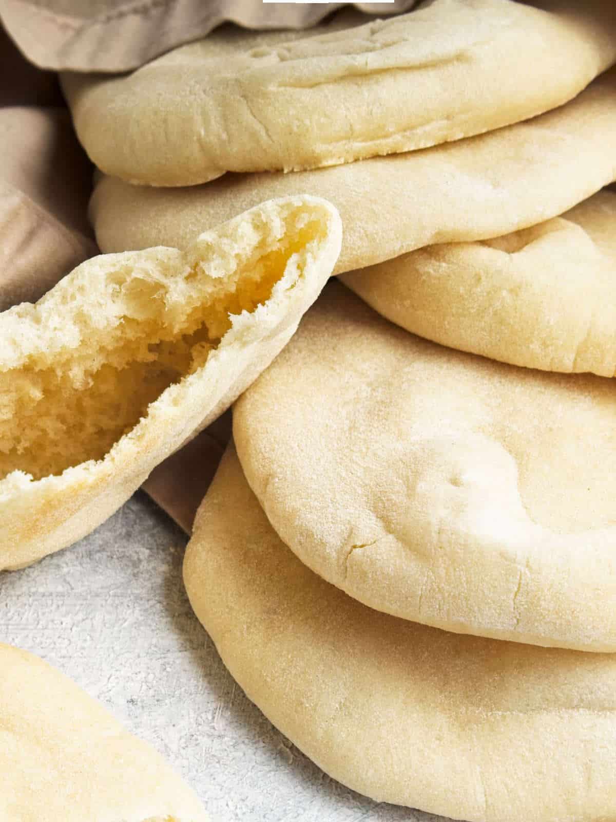 mini pita bread cooling on a wood cutting board.