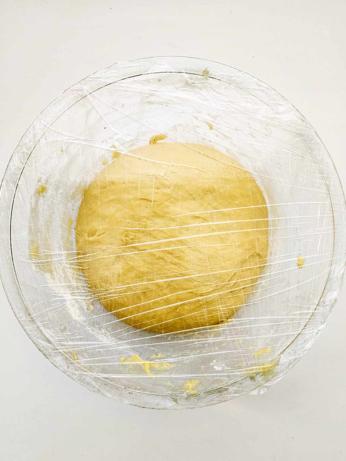 dough proofing in a plastic wrapped bowl.