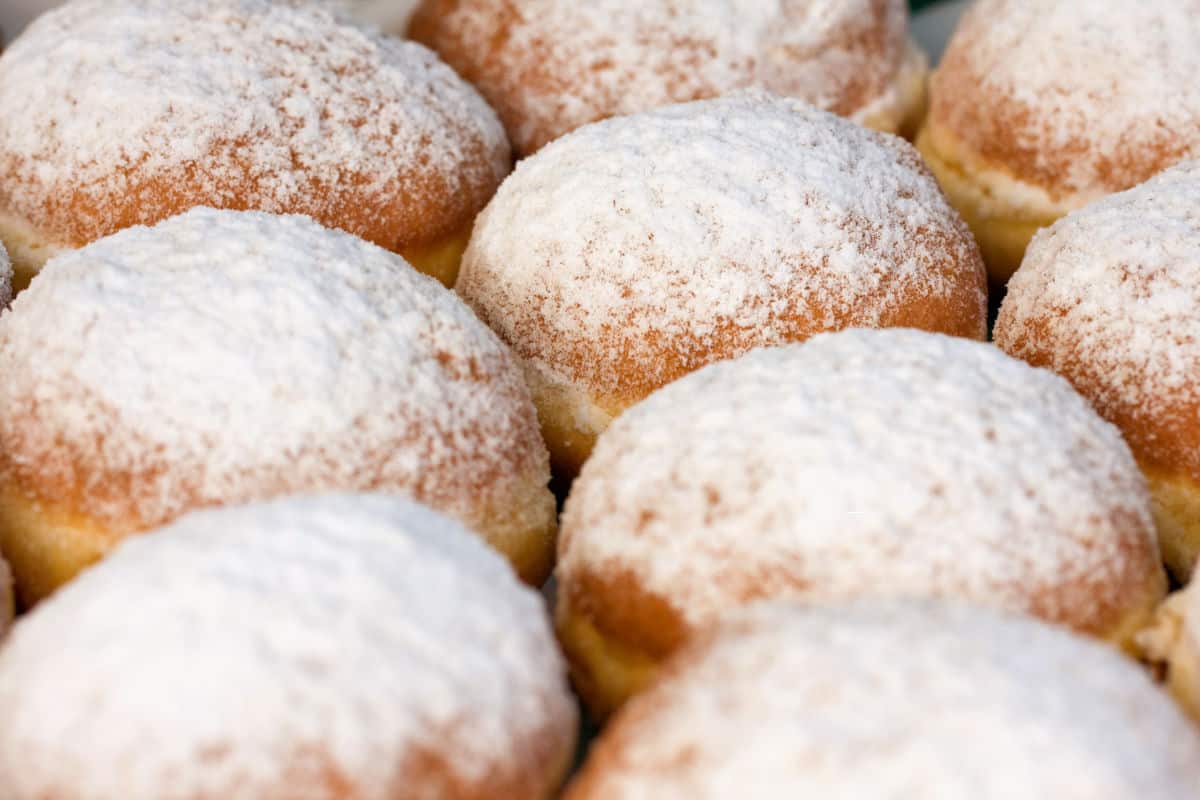 powdered sugar dusted tray of paczki.