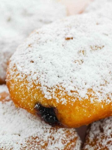 powdered sugar dusted tray of paczki.