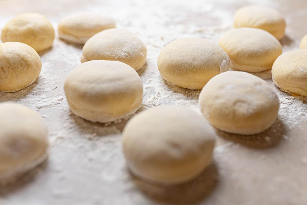 3 inch rounds of paczki dough proofing before frying.