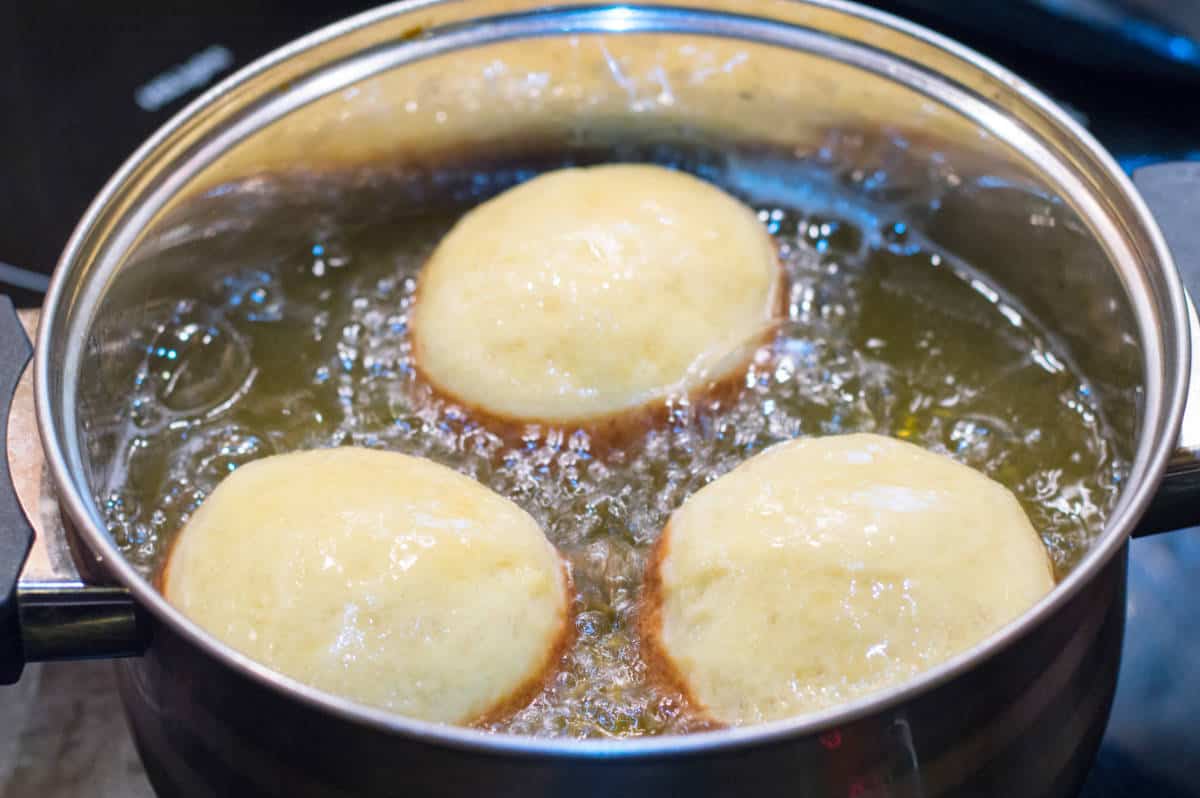 frying paczki in hot vegetable oil.