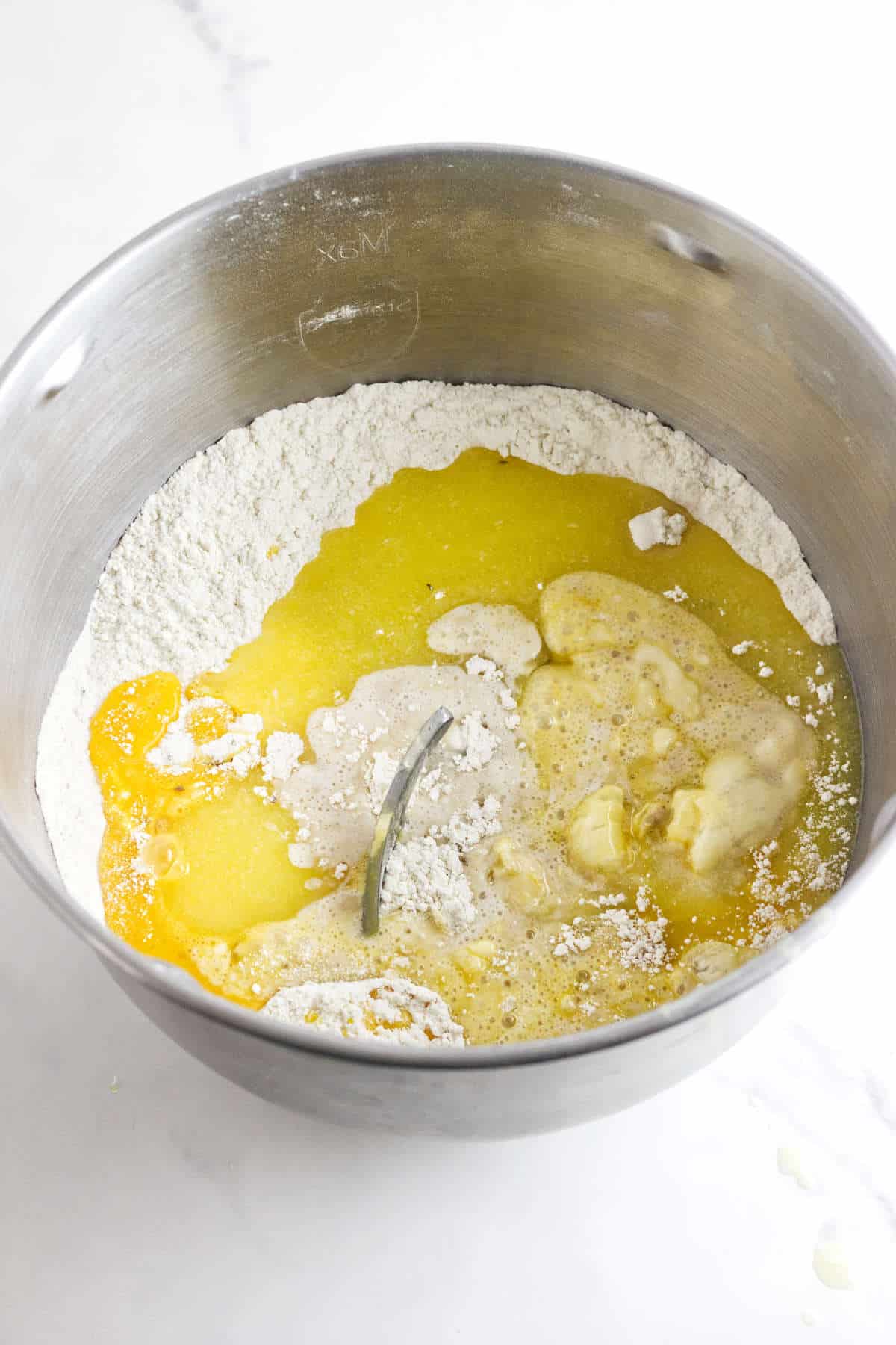 mixing wet and dry ingredients in a mixer for bread dough.