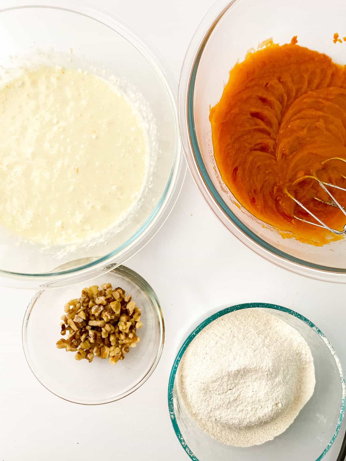 bowls with measured ingredients for making pumpkin bread with a cream cheese swirl or layer.