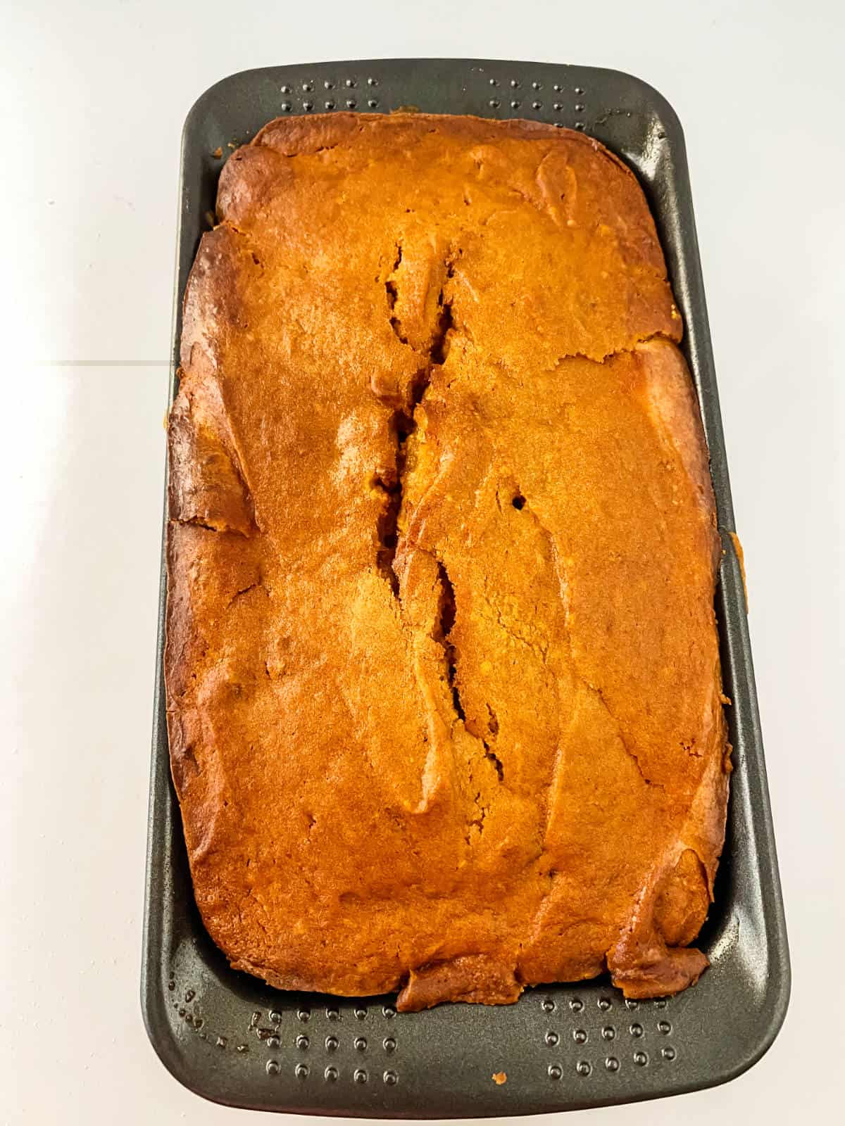 baked pumpkin cream cheese bread in a loaf pan.