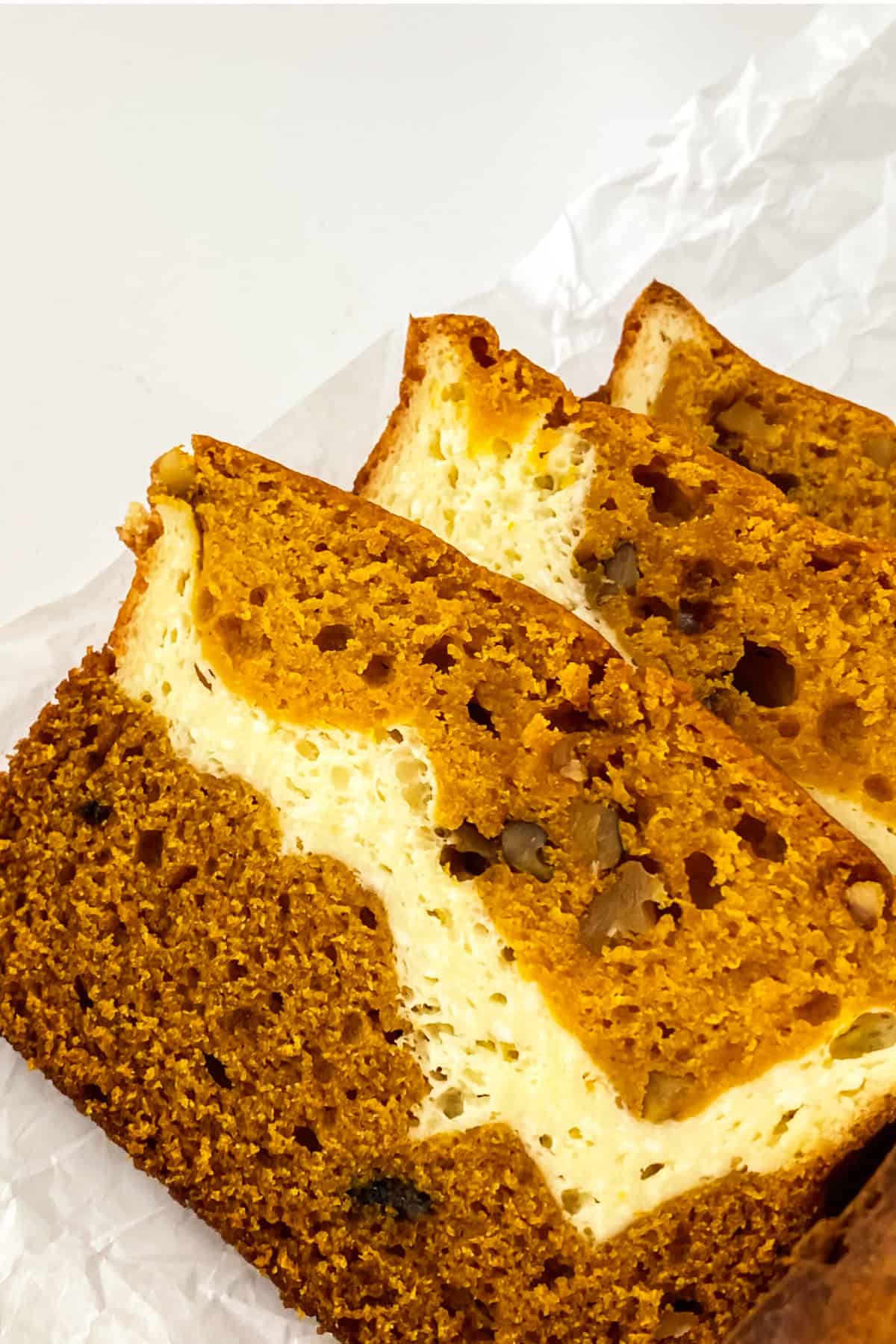 slices of pumpkin cream cheese bread on paper.