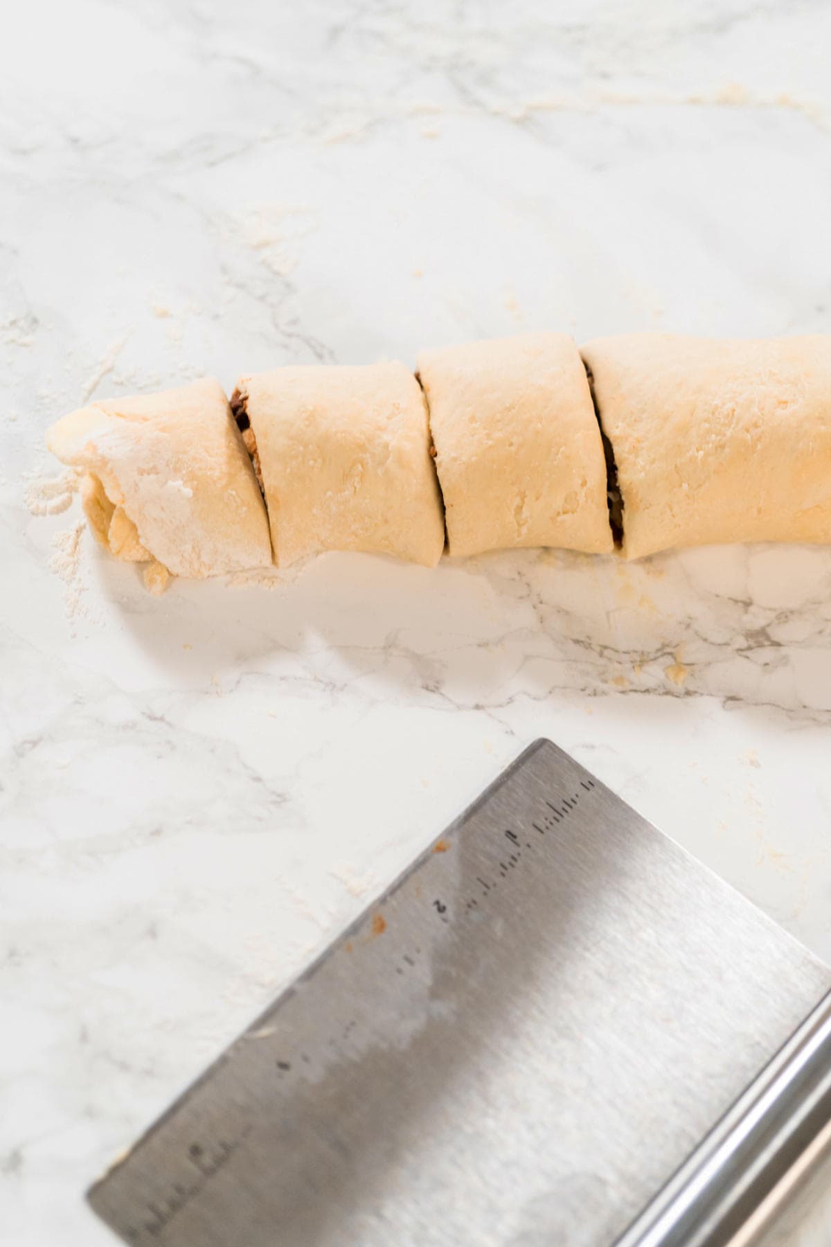 rolled up dough with cinnamon filling being sliced.