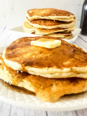 sourdough discard pancakes on a plate with butter and maple syrup.