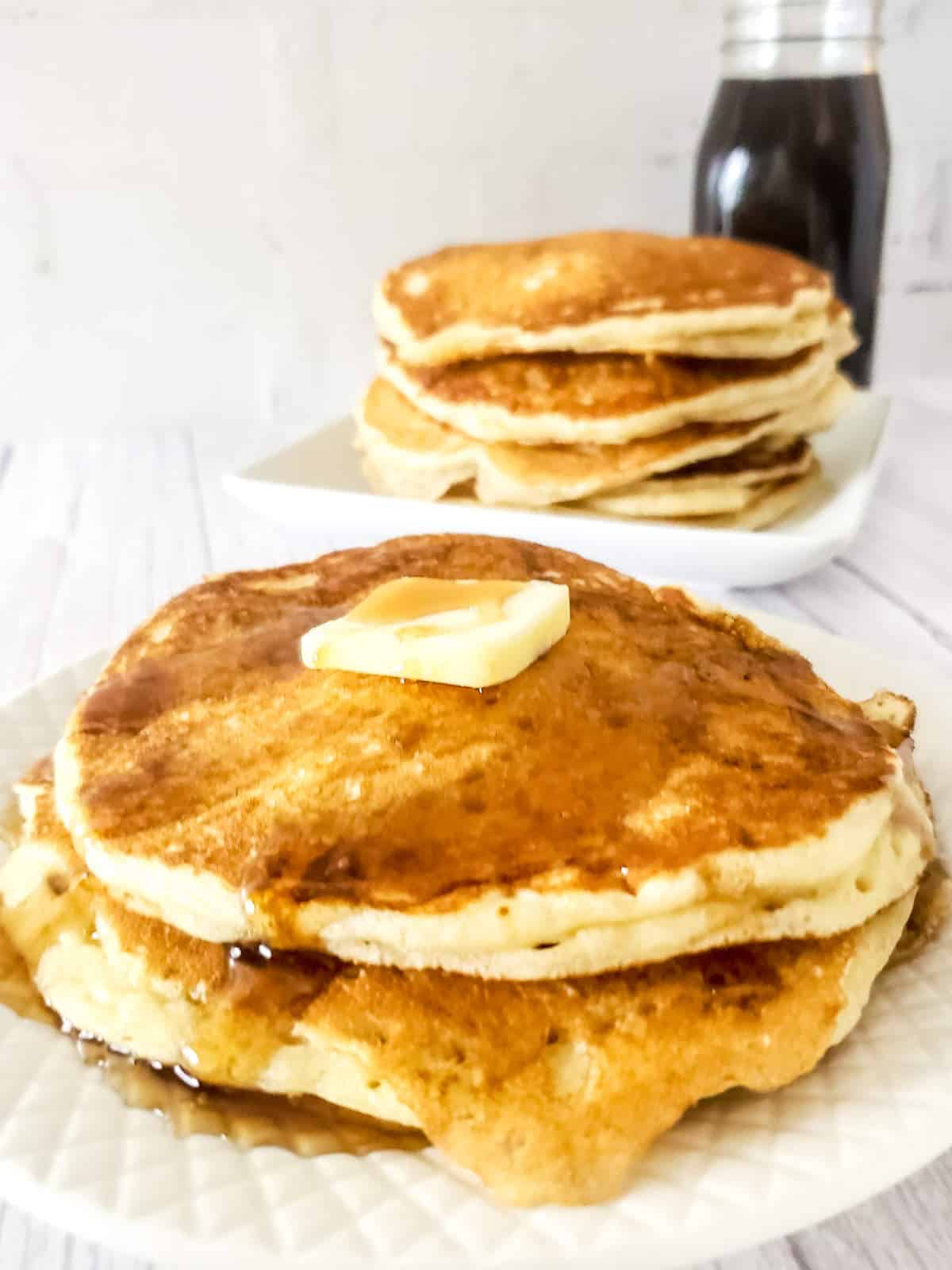 sourdough discard pancakes on a plate with butter and maple syrup.