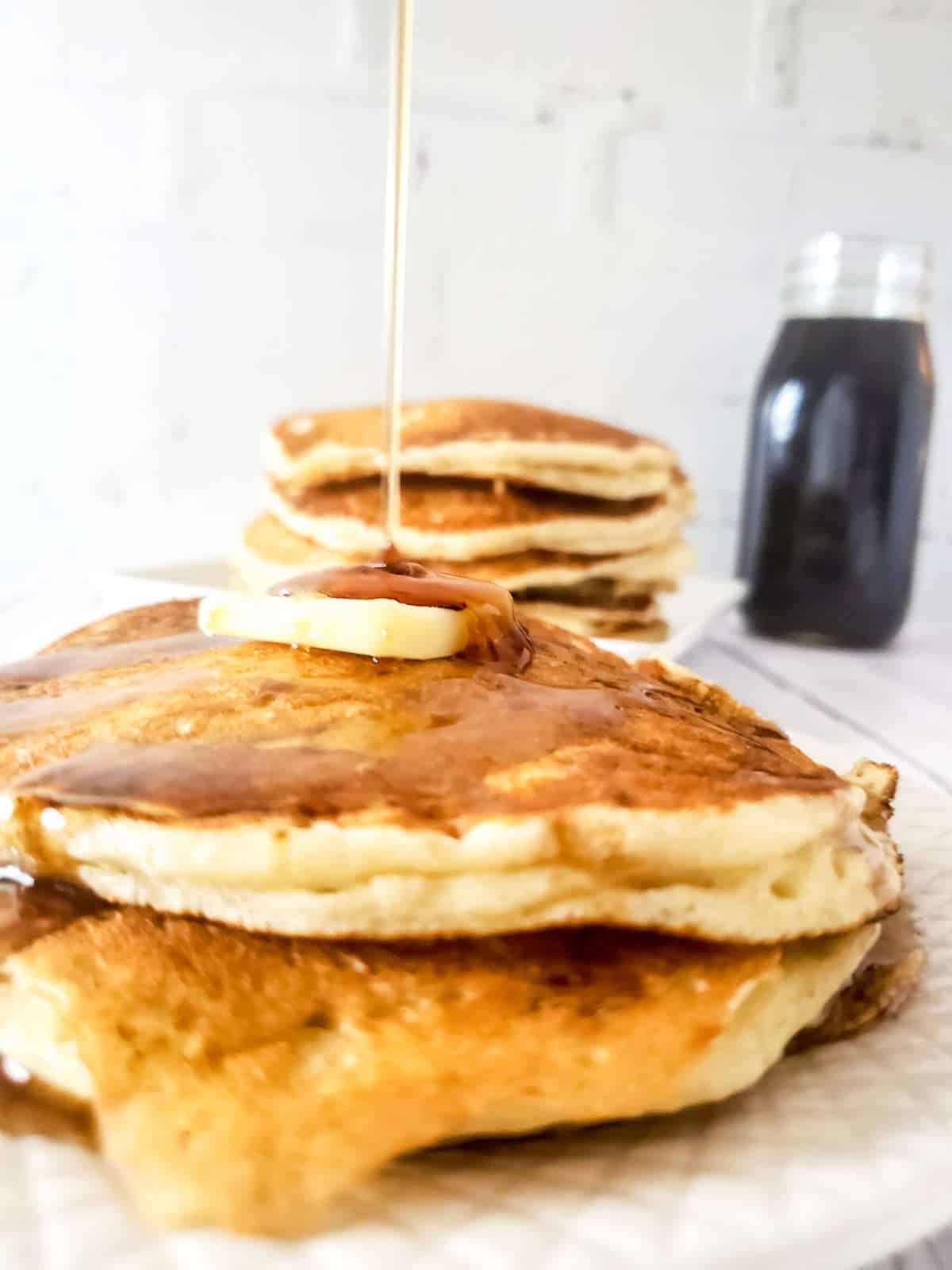 sourdough discard pancakes on a plate with butter and maple syrup.