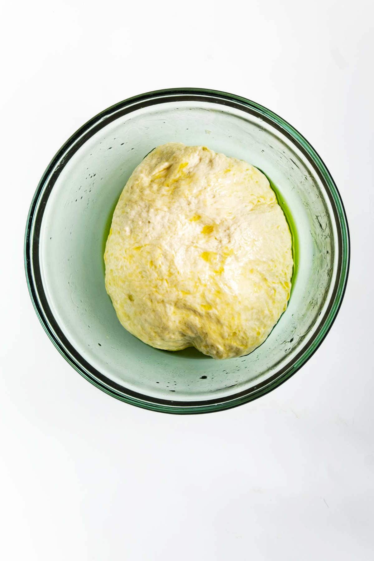 A bowl of dough, ready to be transformed into fragrant roasted garlic focaccia.
