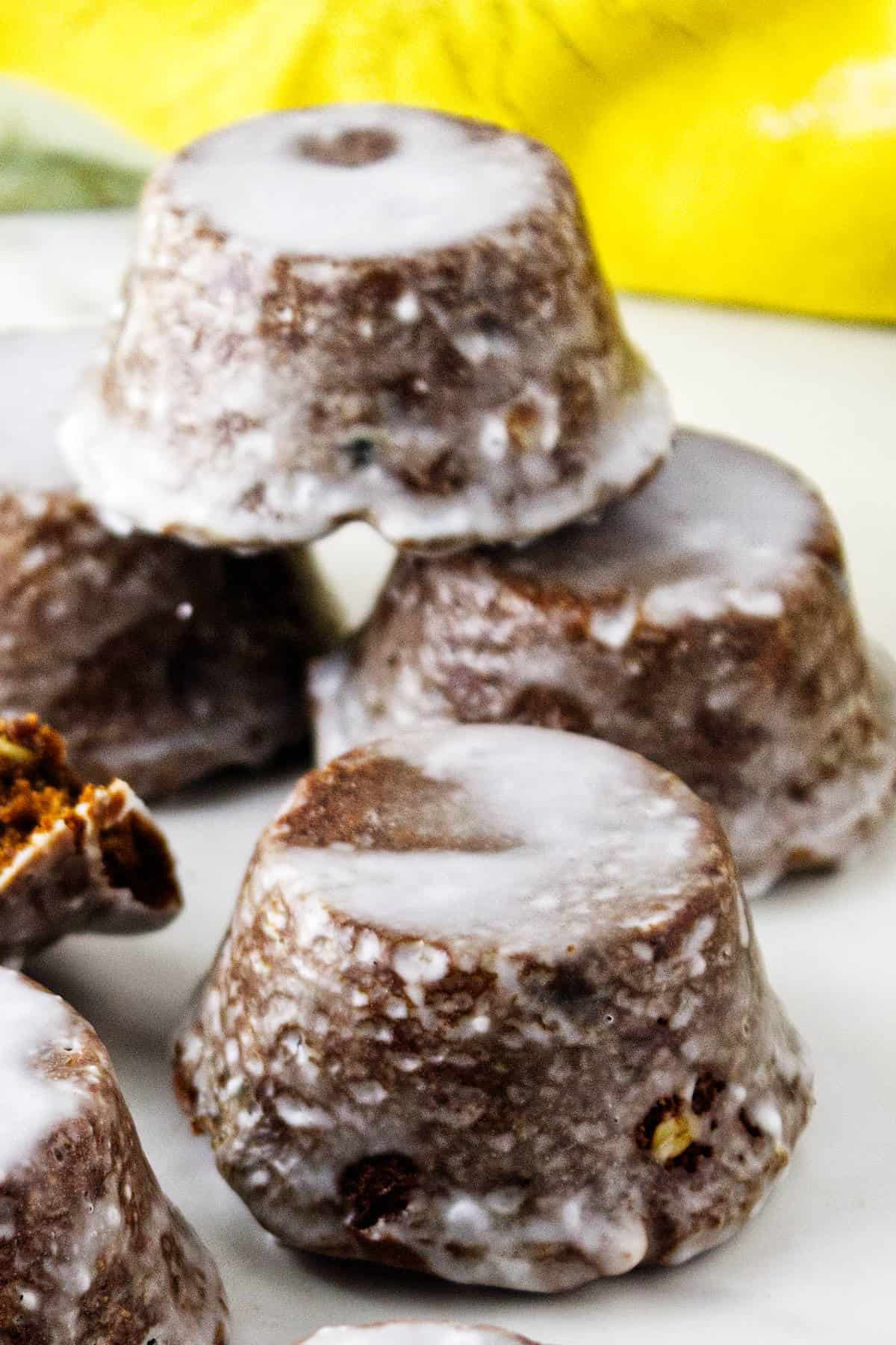 Close-up of upside-down Sailor Jack cakes coated in white glaze, with a cut cake showing its spiced interior.