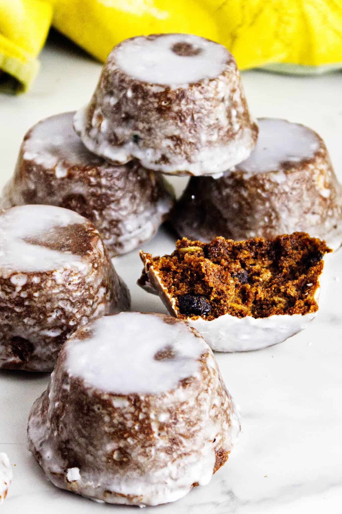 Stacked glazed Sailor Jack muffins, with one split open to show the dark, raisin-studded crumb.